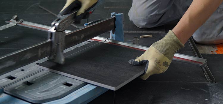 professionnel effectuant la découpe du carrelage