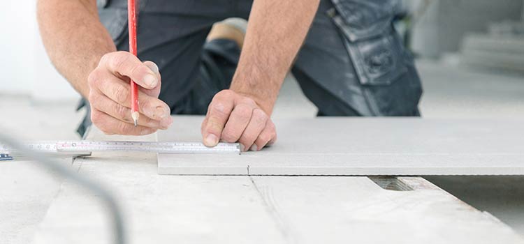 professionnel effectuant des prises de mesures sur du carrelage